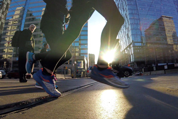 Close up of speedy feet, running across Dundas at University, the sun shining behind